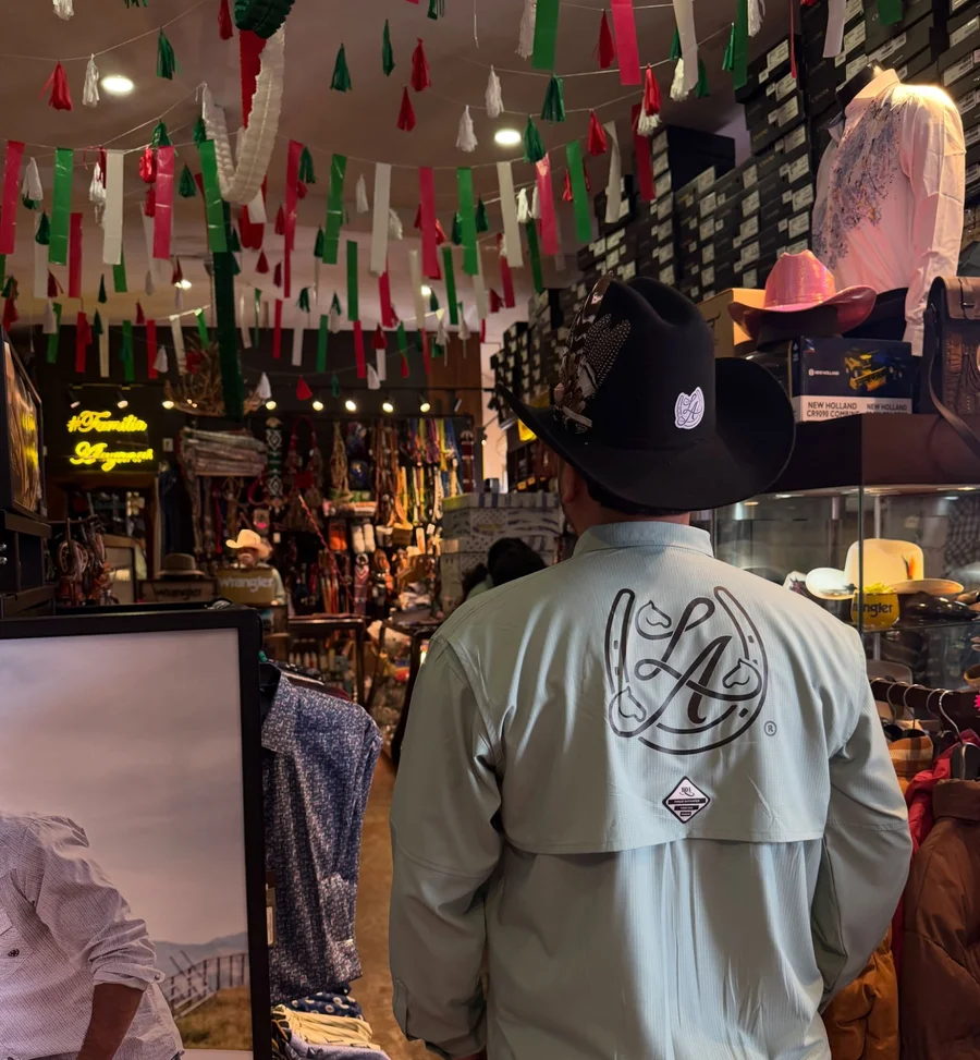 Cliente con sombrero negro y camisa de Las Alazanas recorriendo la tienda