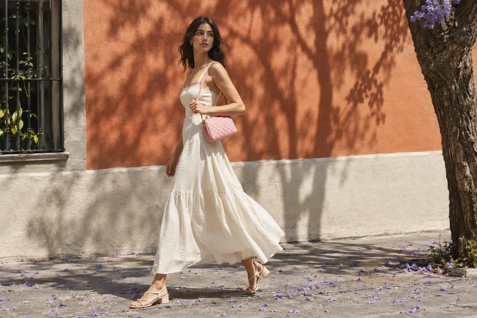Foto de campaña de la colección de primavera: modelo con vestido de lino y bolsa rosa