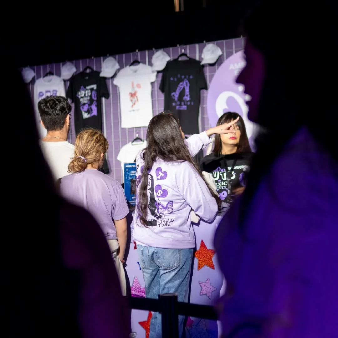 Fan con la sudadera oficial del GUTS World Tour frente a la pared de playeras