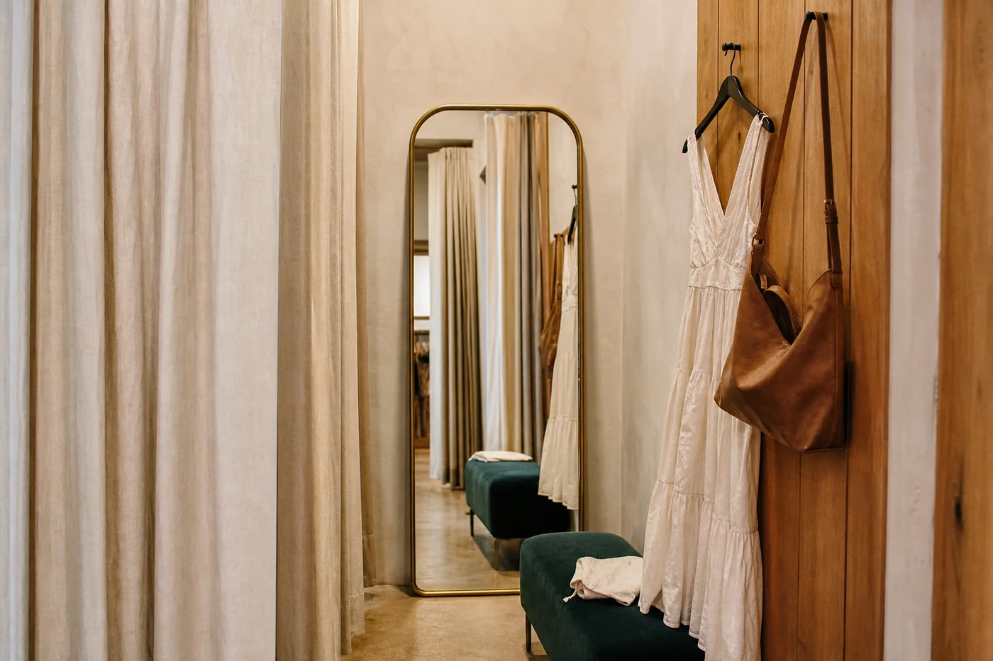 Probadores de una boutique multimarca con cortinas y un espejo de cuerpo entero